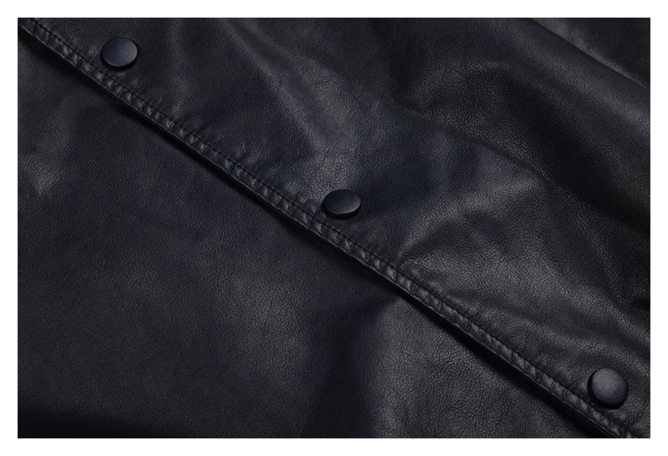 Close-up of the black jacket's textured surface and snap-button placket.