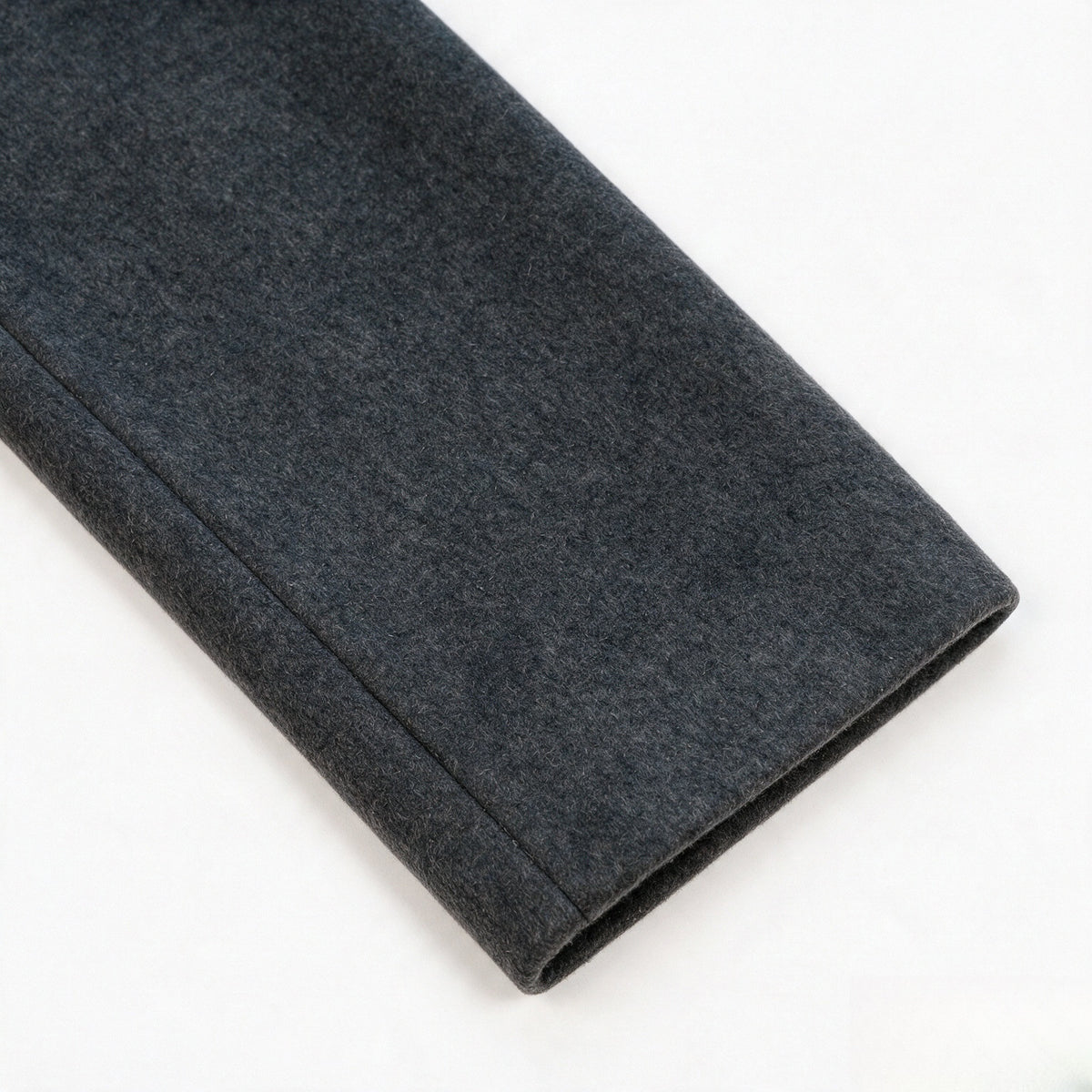 Close-up of a charcoal gray jacket sleeve cuff with a stitched seam.