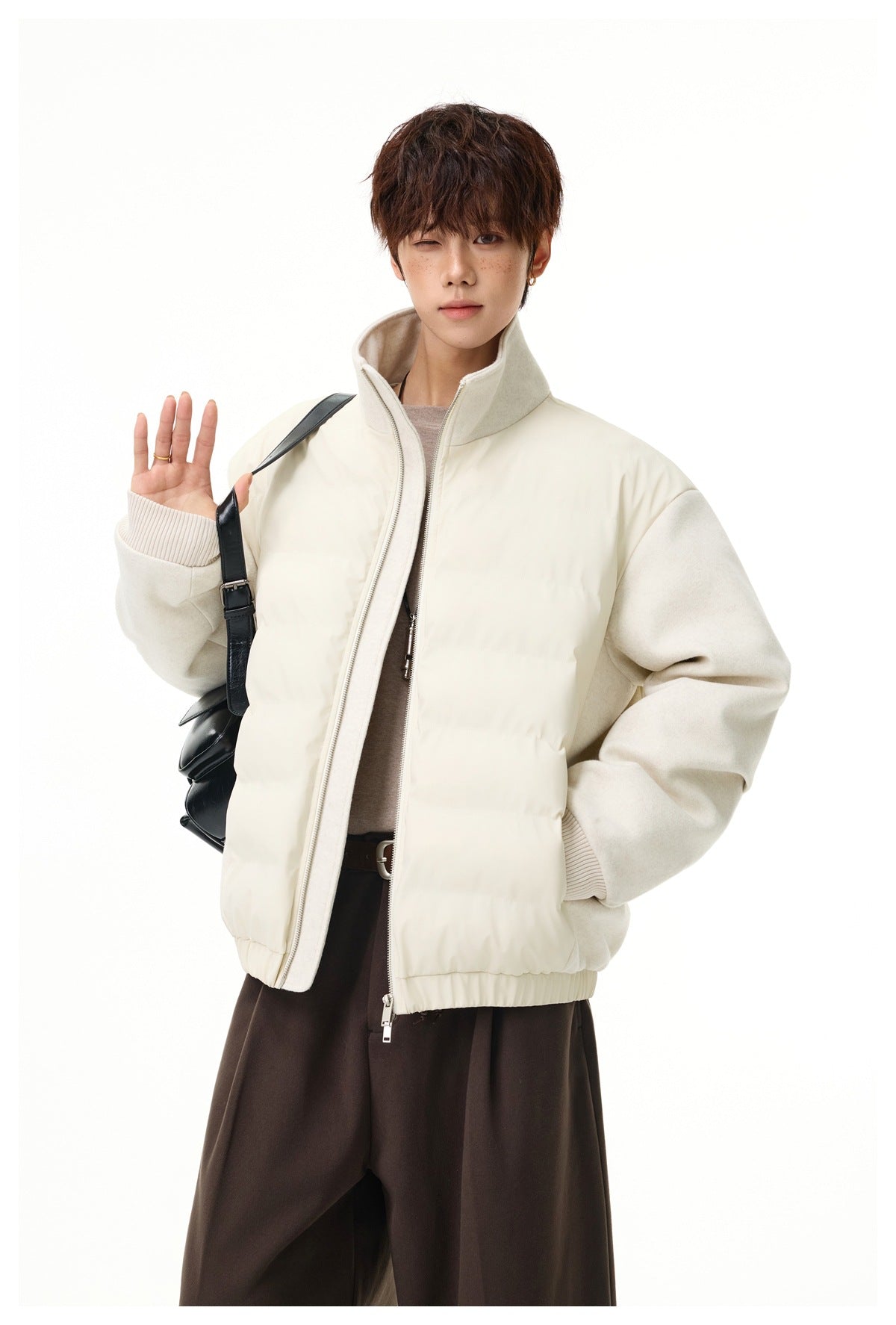 Model wearing an ivory quilted-front jacket with textured sleeves and a high collar, shown from the waist up.