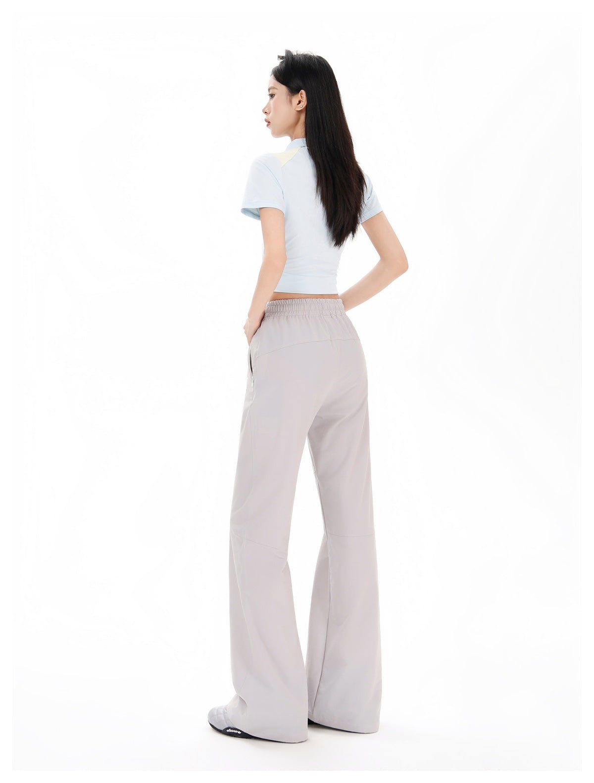Model wearing pale gray wide-leg pants, shown from the back with the elastic waistband and back seams visible.
