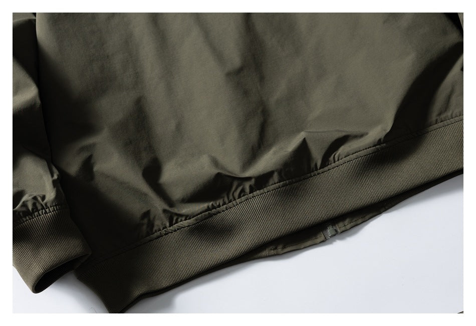 Cropped rear view of the olive green jacket's lower back, ribbed hem, and cuff.