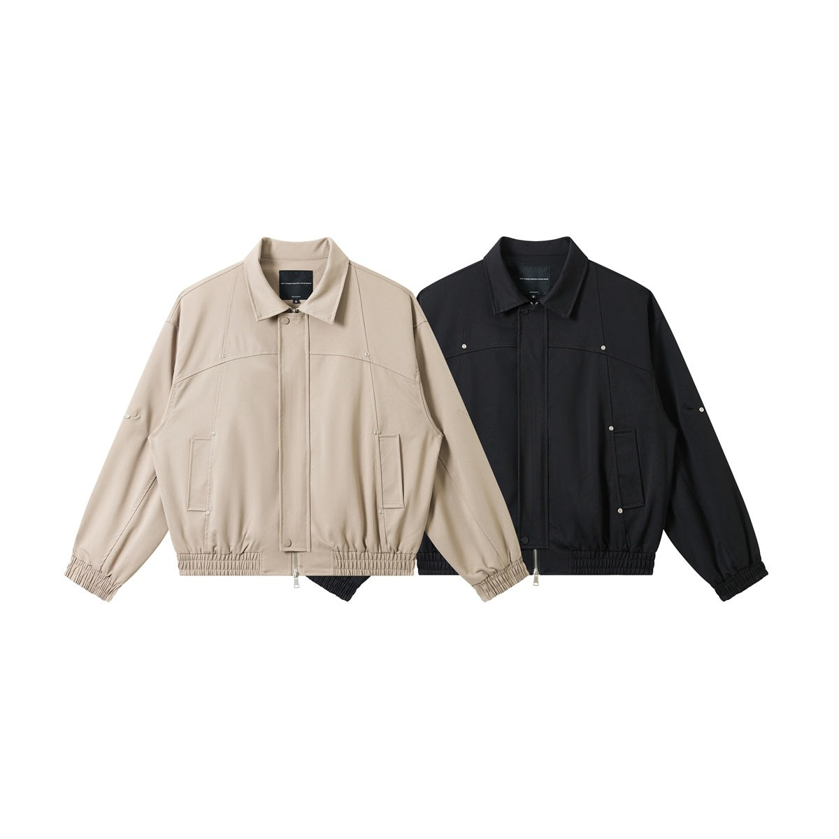 Front view of two collared jackets, one beige and one black, with zip fronts and elastic cuffs and hems.