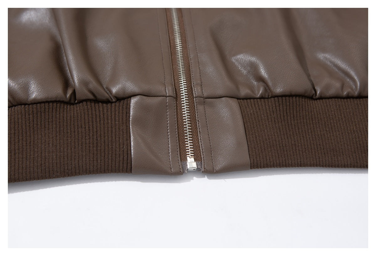 Close-up of the taupe-brown jacket's dark brown ribbed hem and lower front zipper.