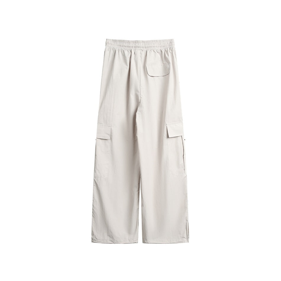 Back view of light beige wide-leg cargo pants with an elastic waist and flap pockets.
