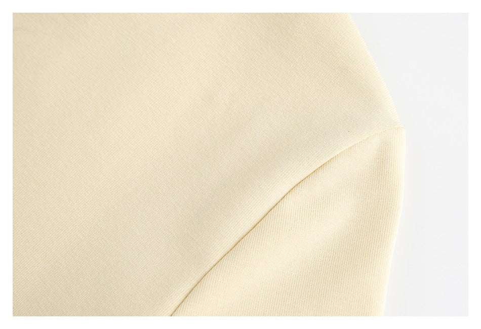 Close-up of a curved seam on a pale cream garment.