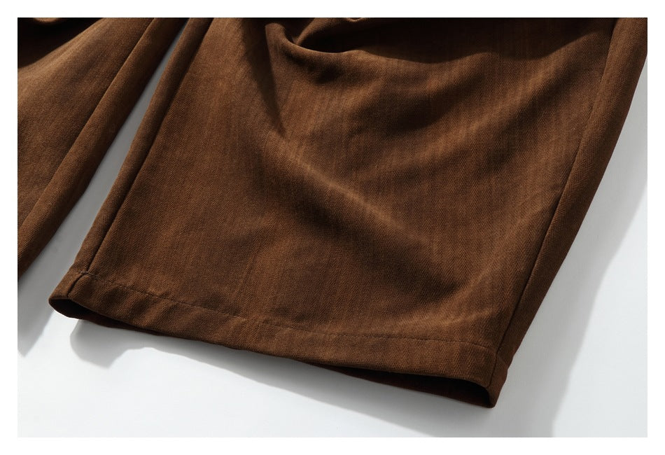 Close-up of a dark brown trouser leg and its stitched hem.