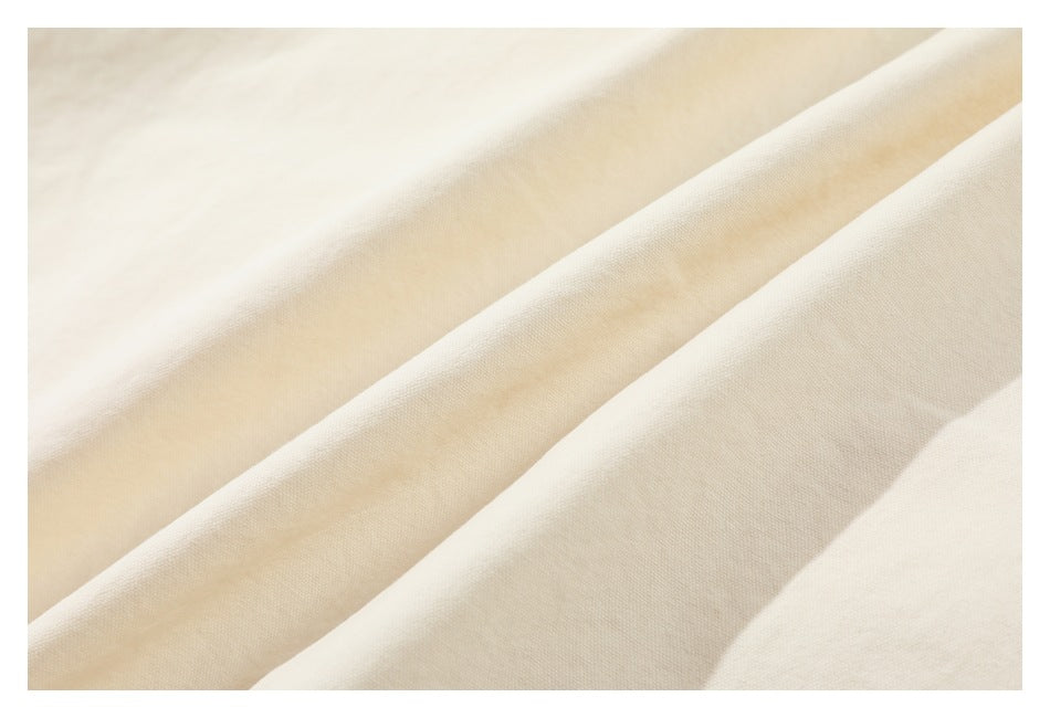 Close-up of softly folded off-white garment fabric.