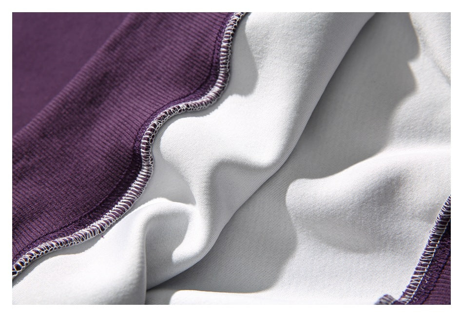 Close-up of the white inside of a purple garment, showing overlocked seam stitching.