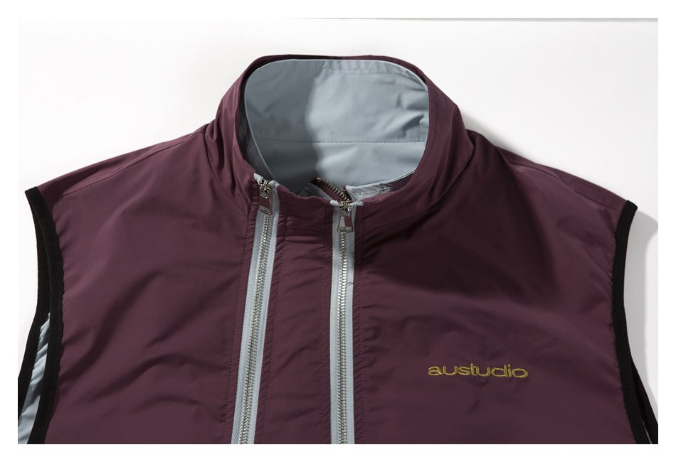 Cropped front view of a burgundy sleeveless vest with twin silver zippers, gray lining, and black armhole trim.