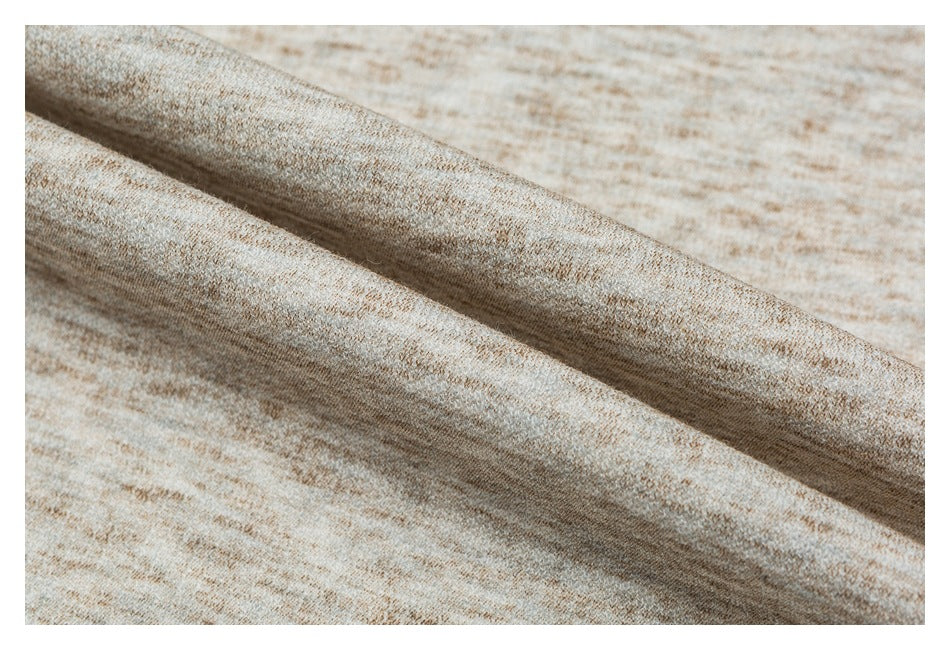 Macro view of the beige and tan marled fabric folded to show its texture.