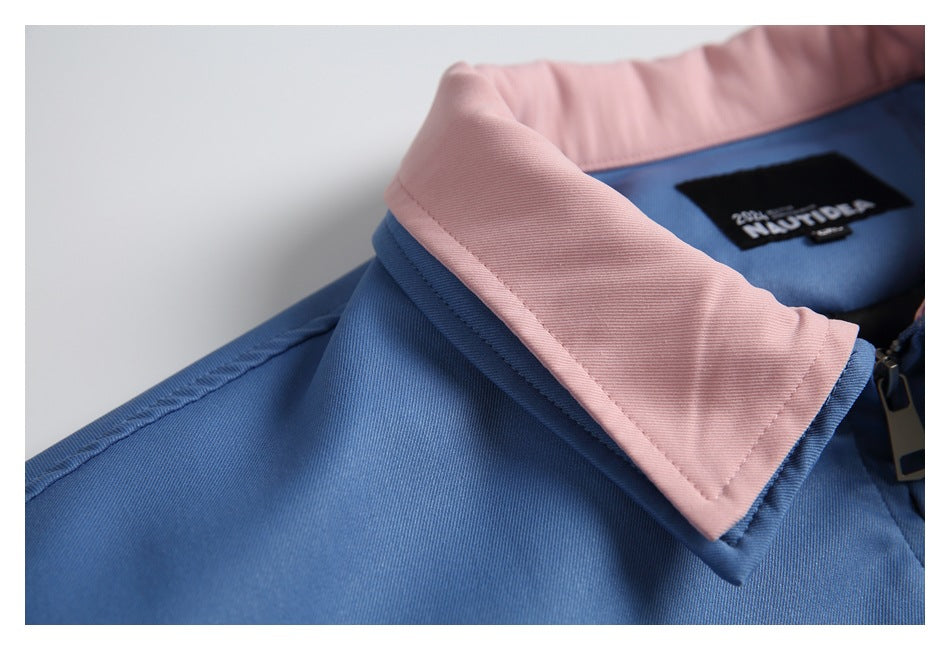Close-up of a blue garment with a pale pink collar and a black label inside the neckline.