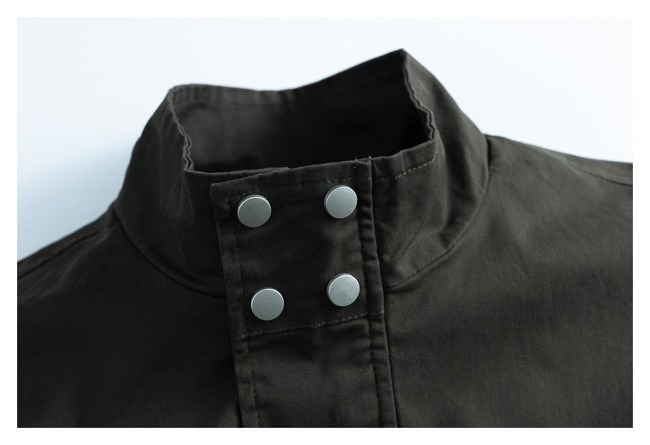 Close-up of a dark jacket’s stand collar and front placket with four silver snaps.