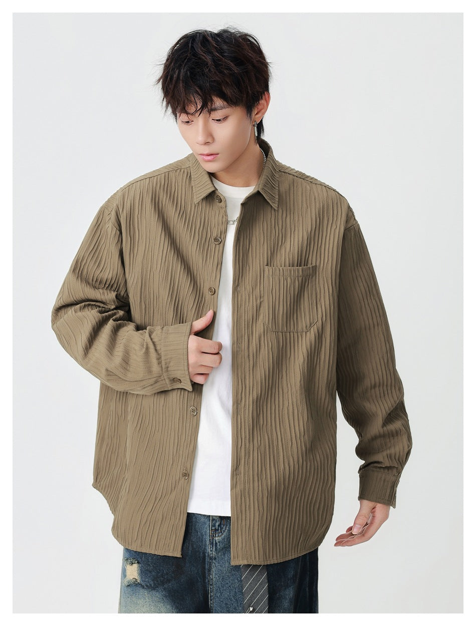 Front view of a model wearing an oversized taupe ribbed button-up shirt with a single chest pocket.