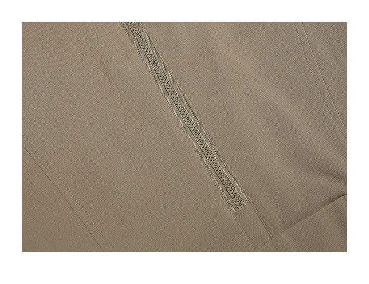 Close-up of a narrow zipper and stitched seams on taupe jacket fabric.