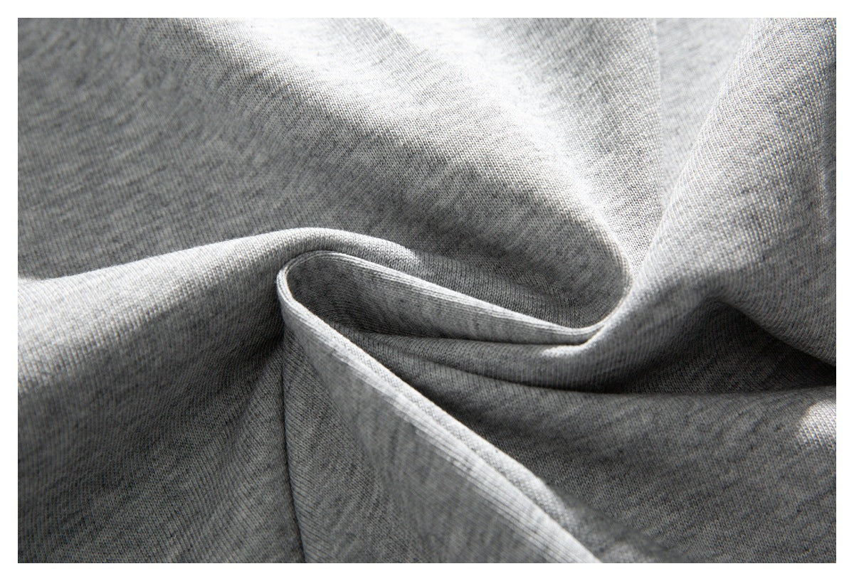 Close-up of gray knit fabric arranged in soft folds, showing its fine textured surface.