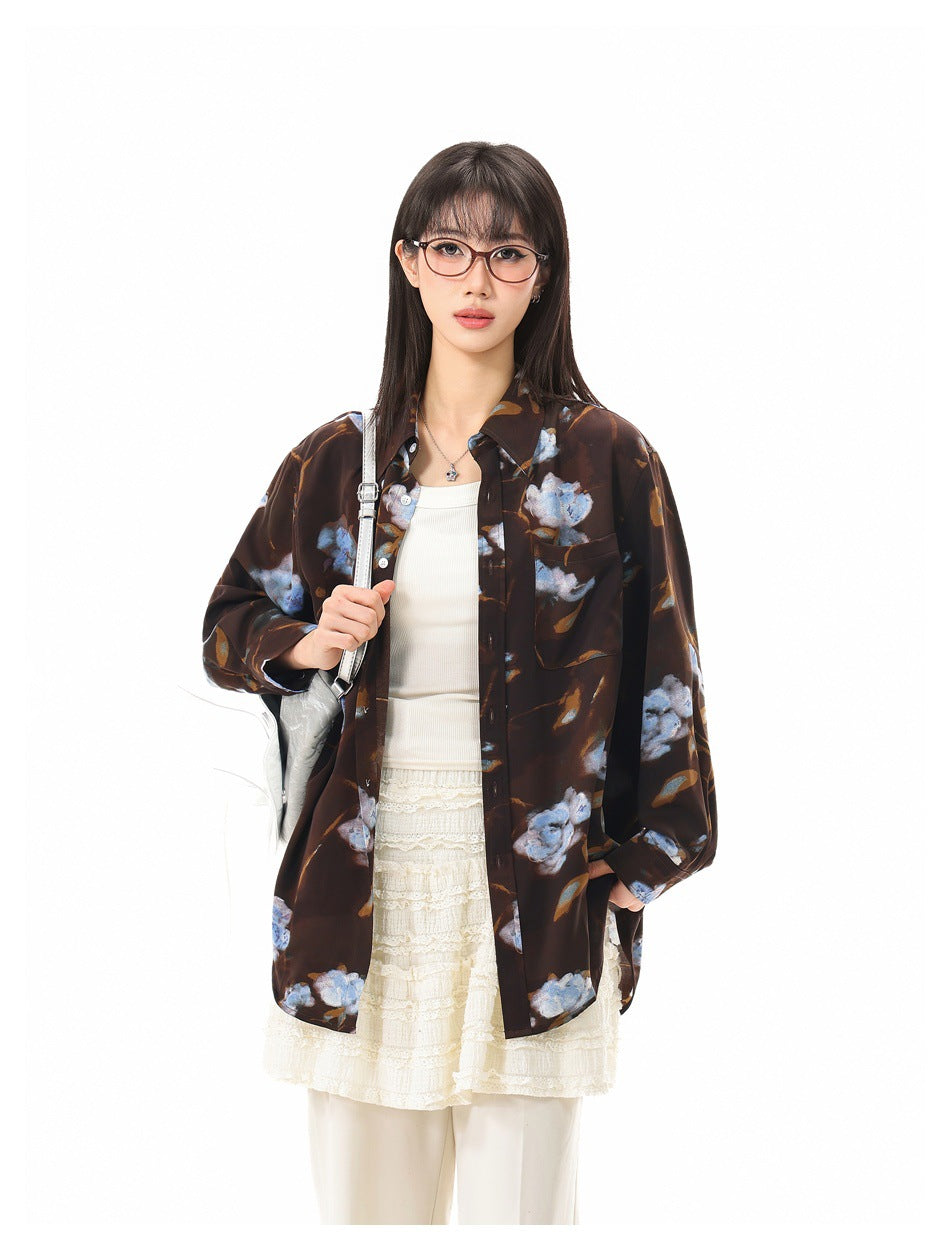 Close-up of a model wearing the brown floral button-up shirt over a cream tank top and lace skirt