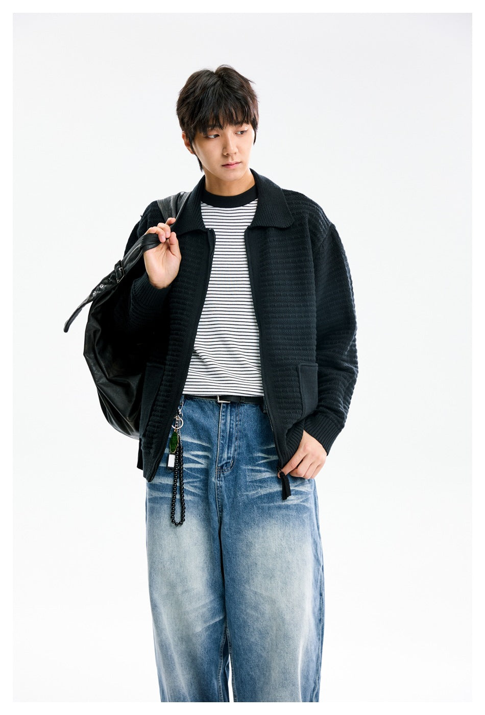Closer front view of a model wearing a black textured knit jacket with a wide collar and patch pockets.