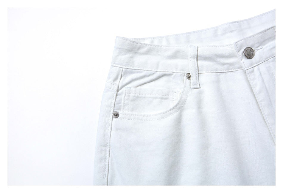 Close-up of white jeans showing the waistband, button, belt loop, and front pocket.