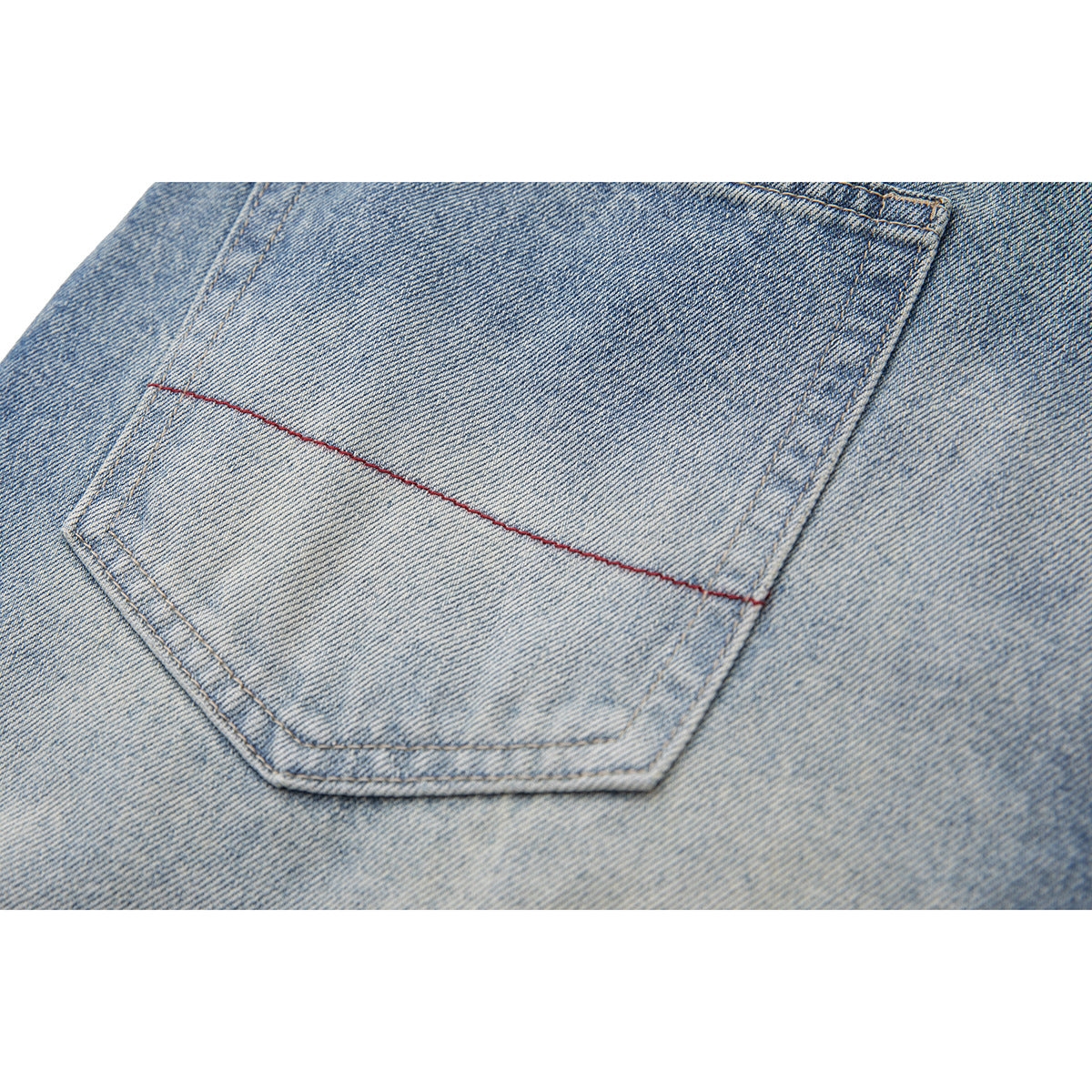 Close-up of a rear pocket on faded light-blue jeans, with a line of red stitching.