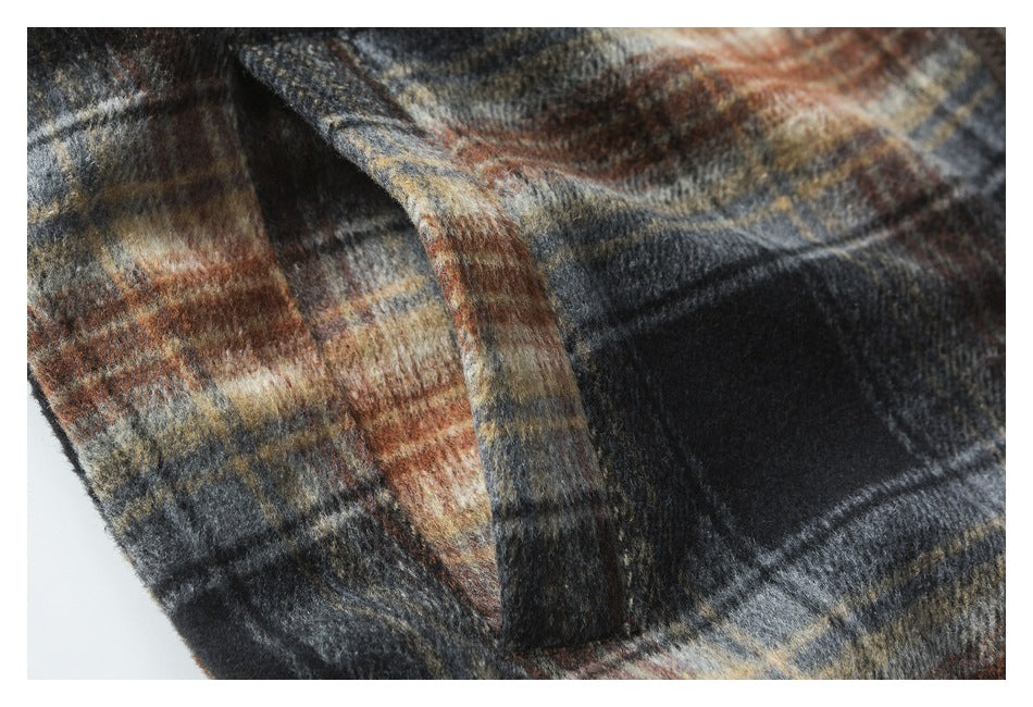 Close-up of a plaid jacket pocket and the surrounding dark, rust, cream, and gray checks.