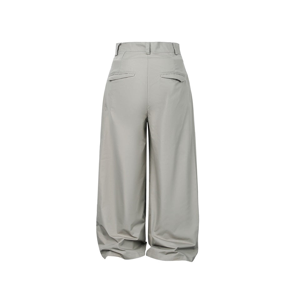 Back view of loose, wide-leg gray trousers with two buttonless welt pockets.