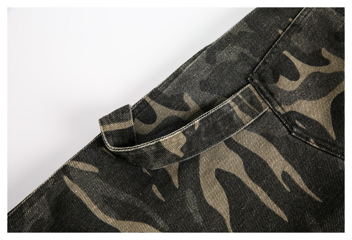 Close-up of a belt loop and stitched seams on charcoal and khaki camouflage trousers.