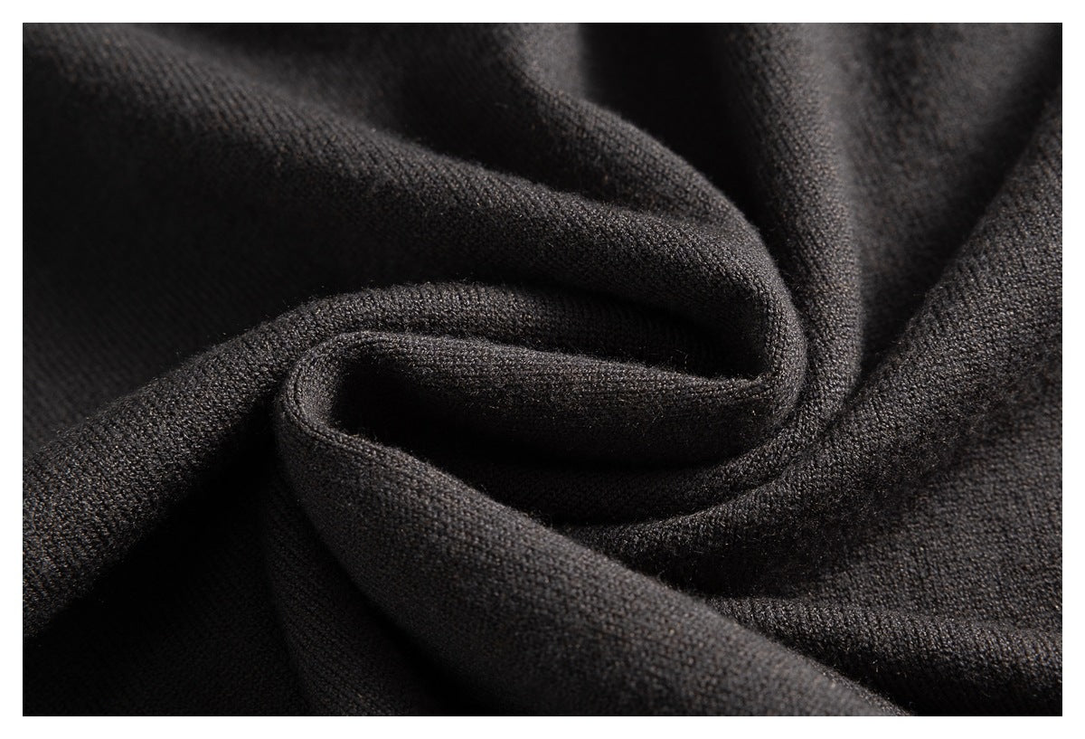 Close-up of dark charcoal knit fabric arranged in soft folds, showing its fine textured surface.