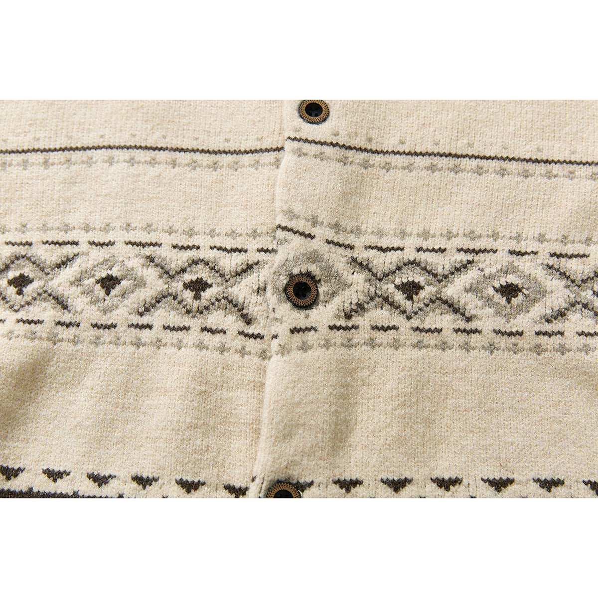 Close-up of a cream knit cardigan’s dark geometric patterned band and front buttons.