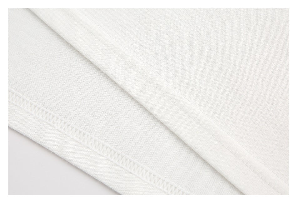 Close-up of white fabric with a folded edge and visible overlock stitching.