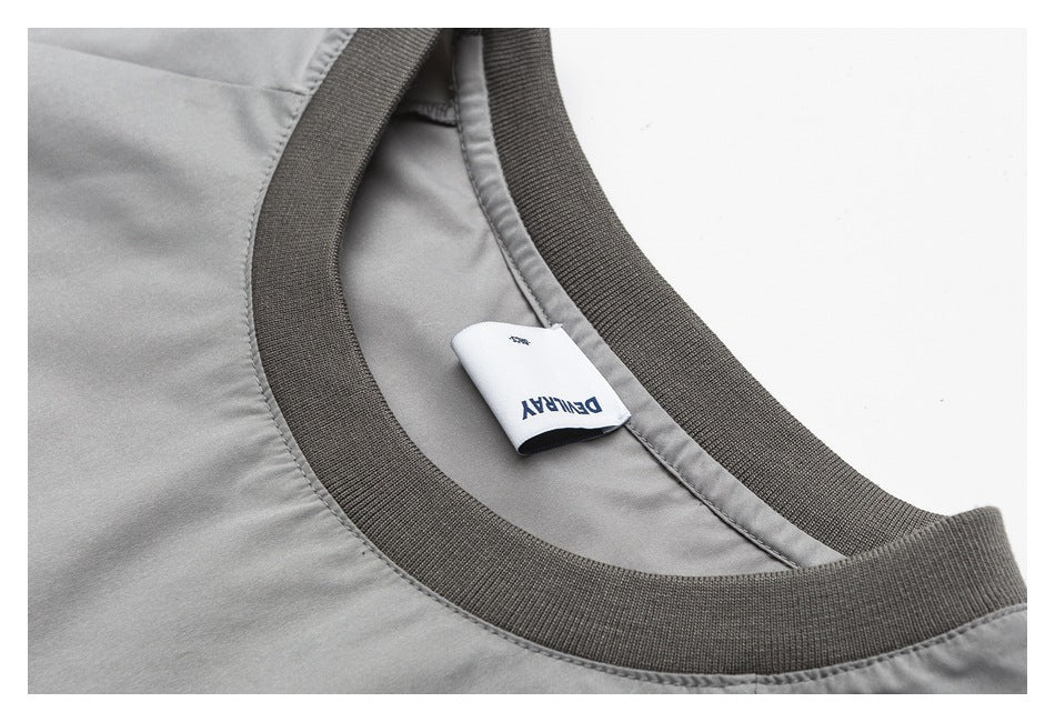 Close-up of a gray garment's ribbed neckline and sewn-in white DENRAY label.