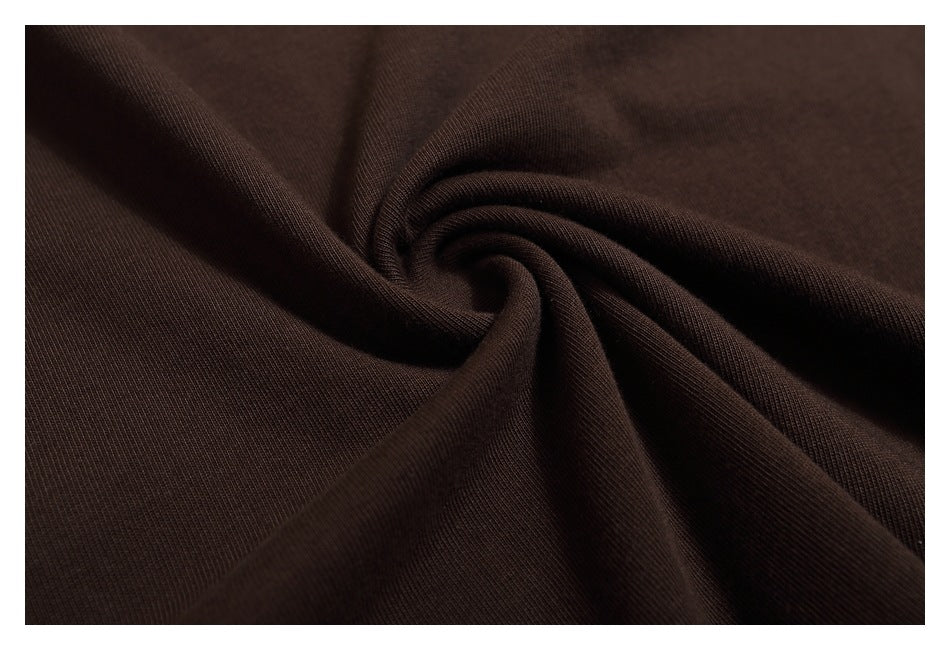 Close-up of dark brown shirt fabric twisted into soft folds.