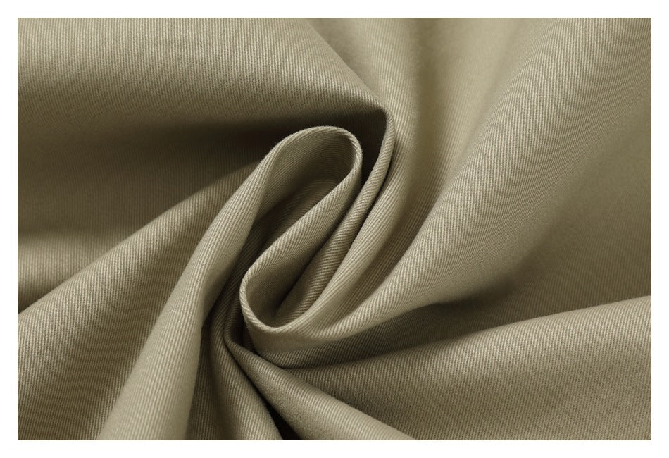 Close-up showing the drape and fine diagonal texture of beige garment fabric.