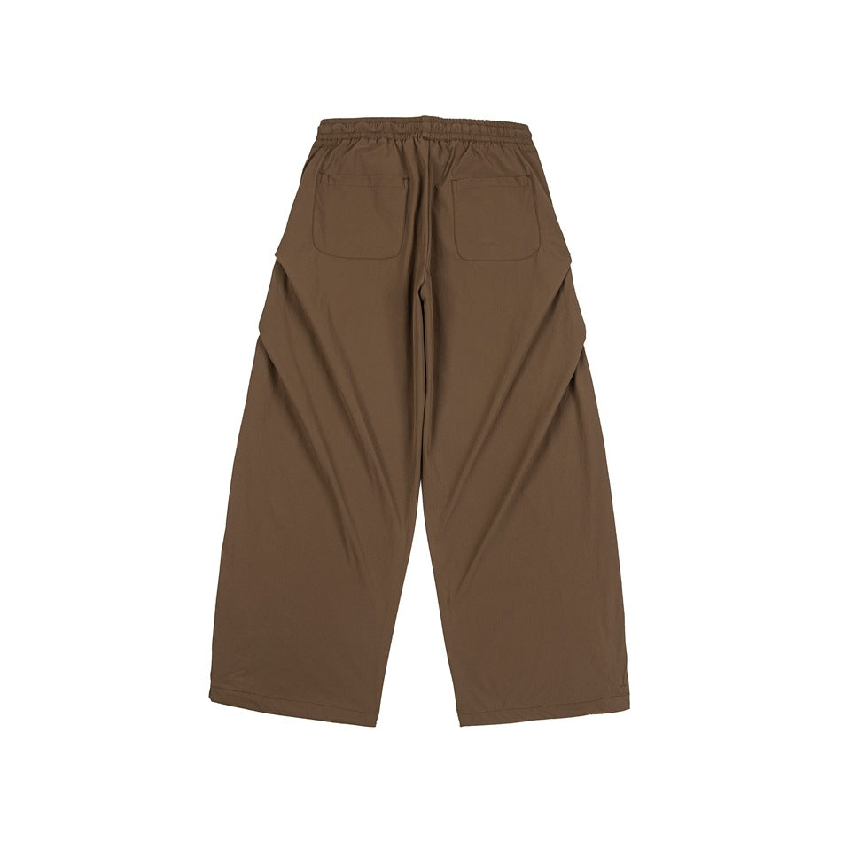 Back view of brown wide-leg pants with an elastic waist and two rear patch pockets.