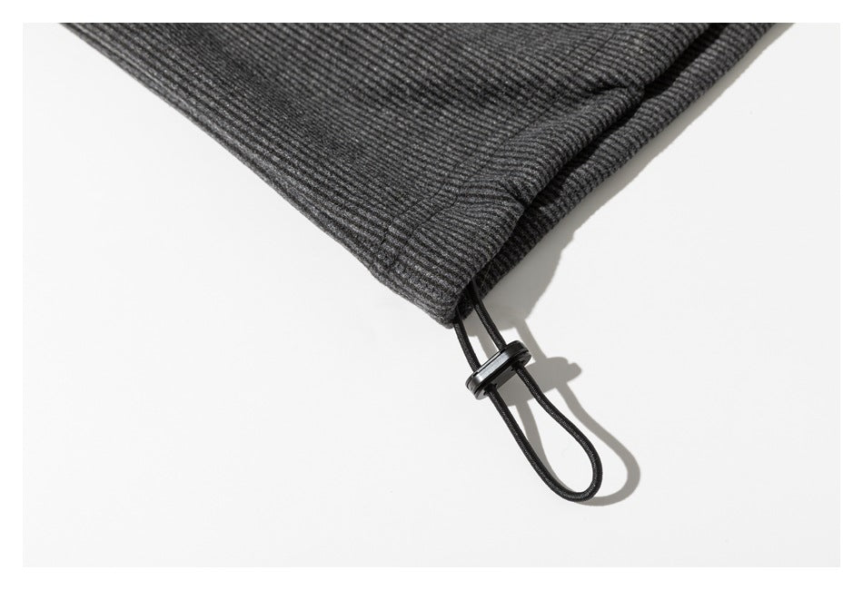 Close-up of a charcoal sweatshirt hem with an adjustable black drawcord and toggle.