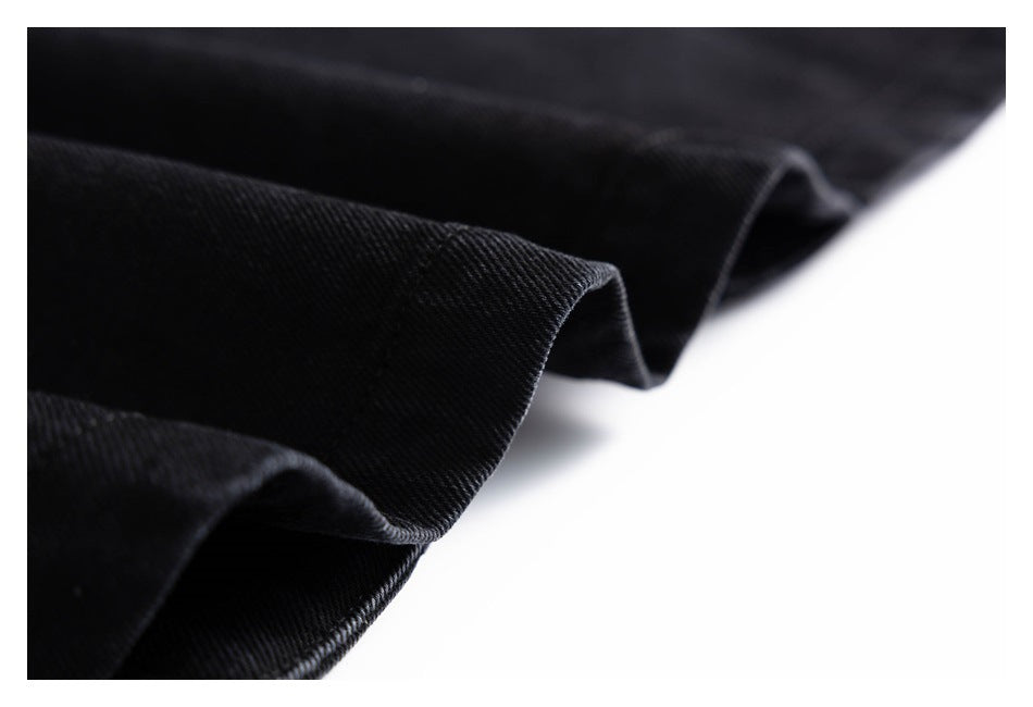 Close-up of folded black garment edges showing stitched hems and fabric texture.