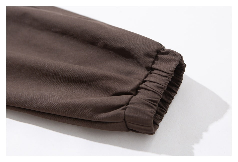 Close-up of a dark brown jacket sleeve ending in a gathered elastic cuff.