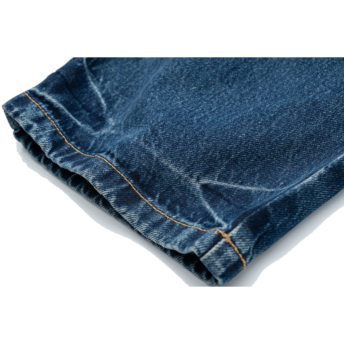 Close-up of the dark blue jeans' folded leg hem with contrast stitching.