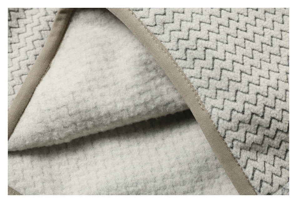 Close-up showing the soft, light-colored inner surface and beige binding of zigzag-patterned fabric.
