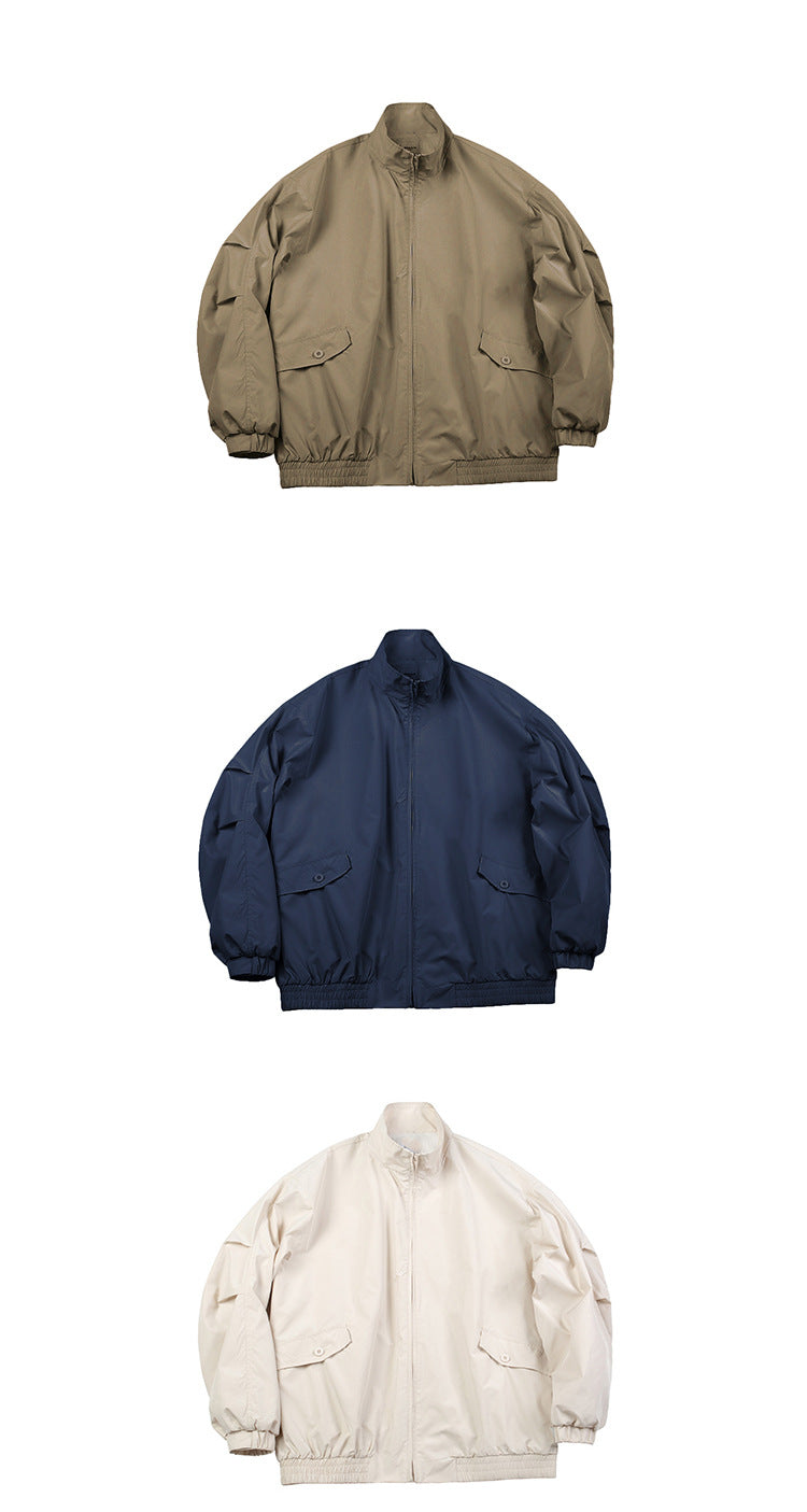 Three front views of a zip-front jacket in khaki, navy, and ivory, with stand collars, flap pockets, and elastic cuffs and