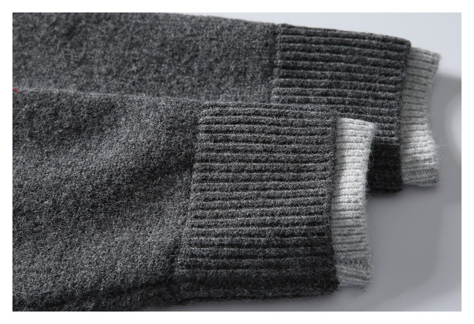 Close-up of two charcoal sweater sleeve cuffs with light gray contrast edges.