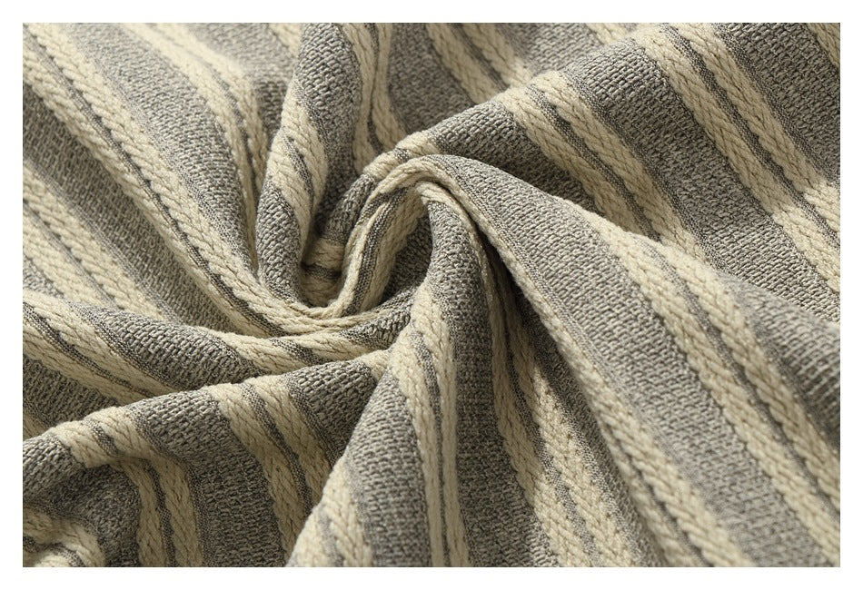 Extreme close-up of gray and cream striped fabric gathered into folds.