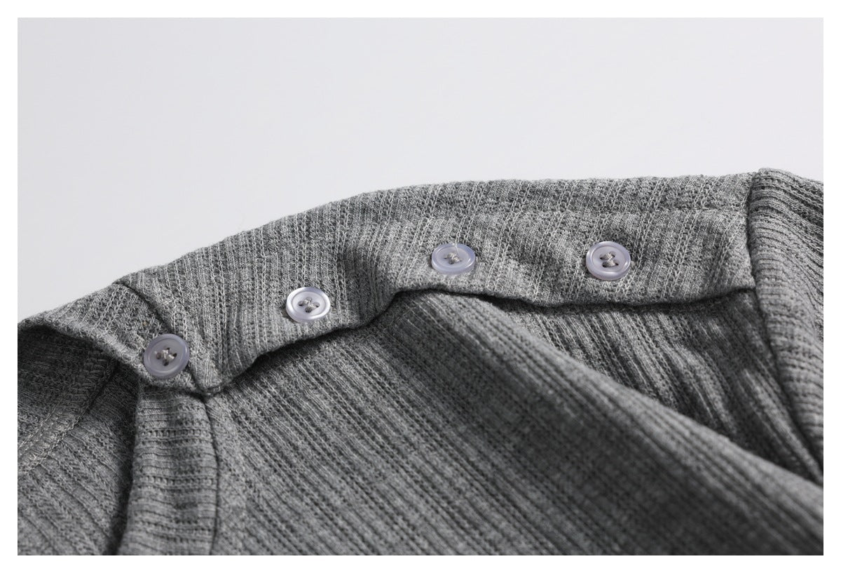 Close-up of a gray ribbed knit garment with a folded button placket and four pale buttons.