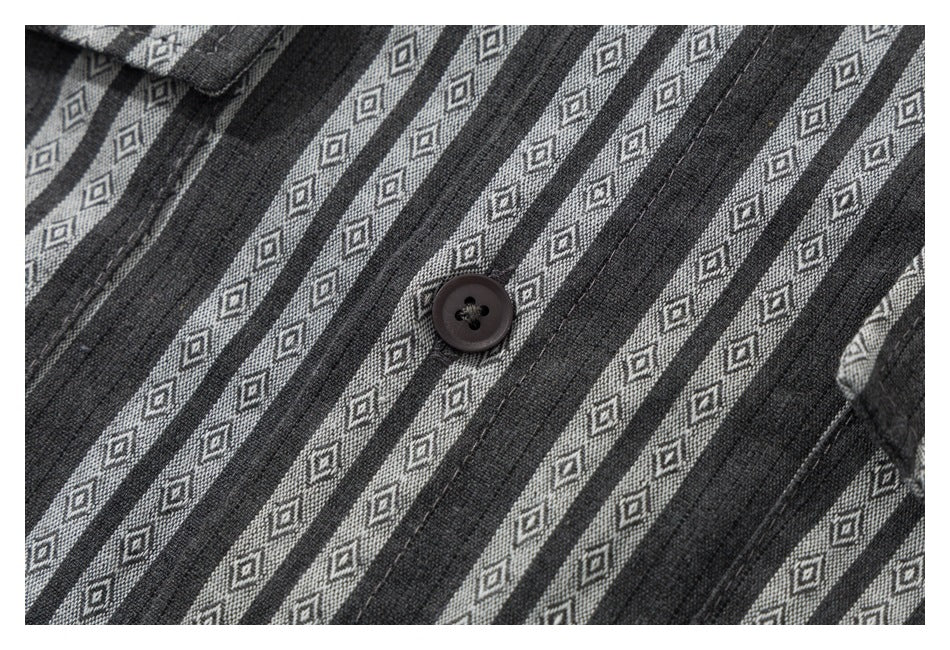 Close-up of a dark gray shirt with narrow diamond-patterned stripes and a dark button.