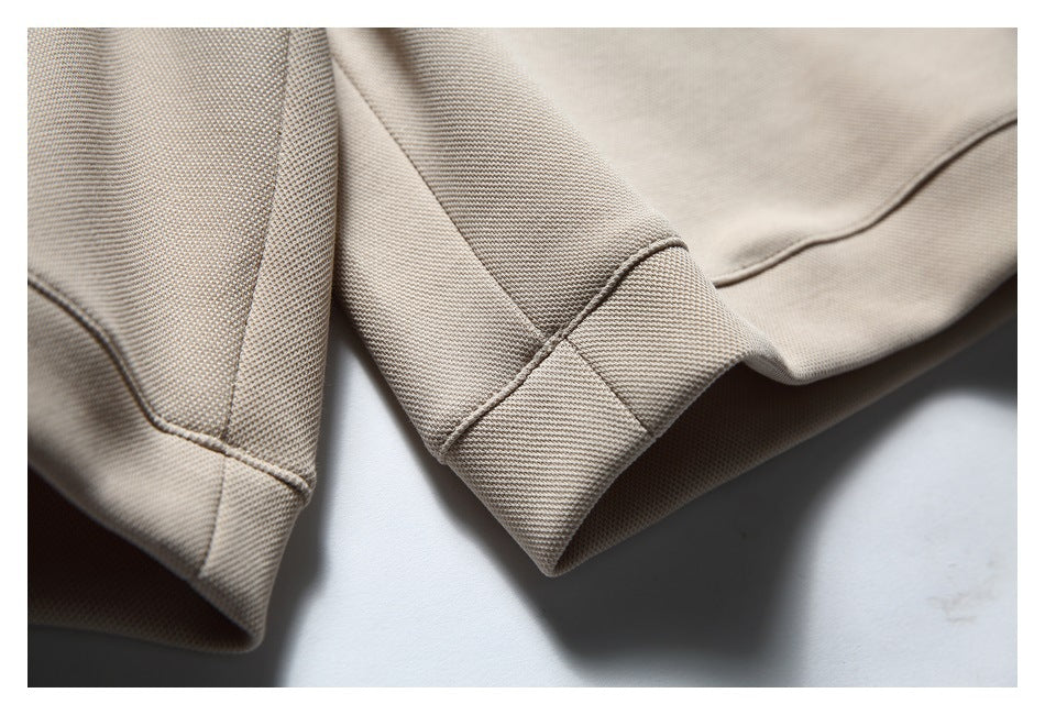 Close-up of stitched hems on a light beige garment.