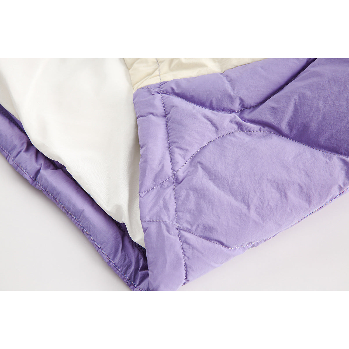 Close-up of a lavender quilted vest opened to show its light-colored lining and curved stitching.