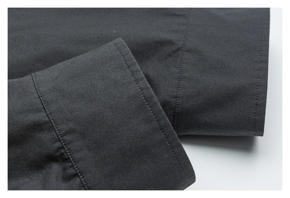 Close-up of a dark garment's folded cuff and seam stitching.