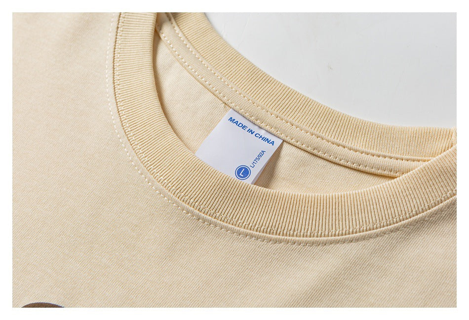 Close-up of a beige T-shirt’s ribbed crew neck and inner label reading “MADE IN CHINA.”