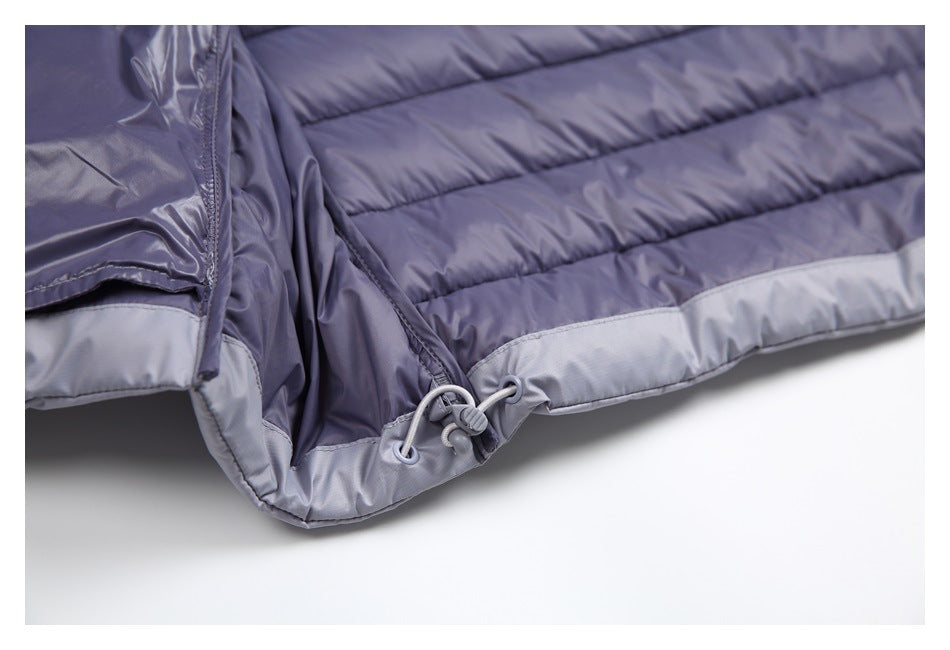 Close-up of a purple quilted garment hem with a light gray panel and adjustable drawcord.