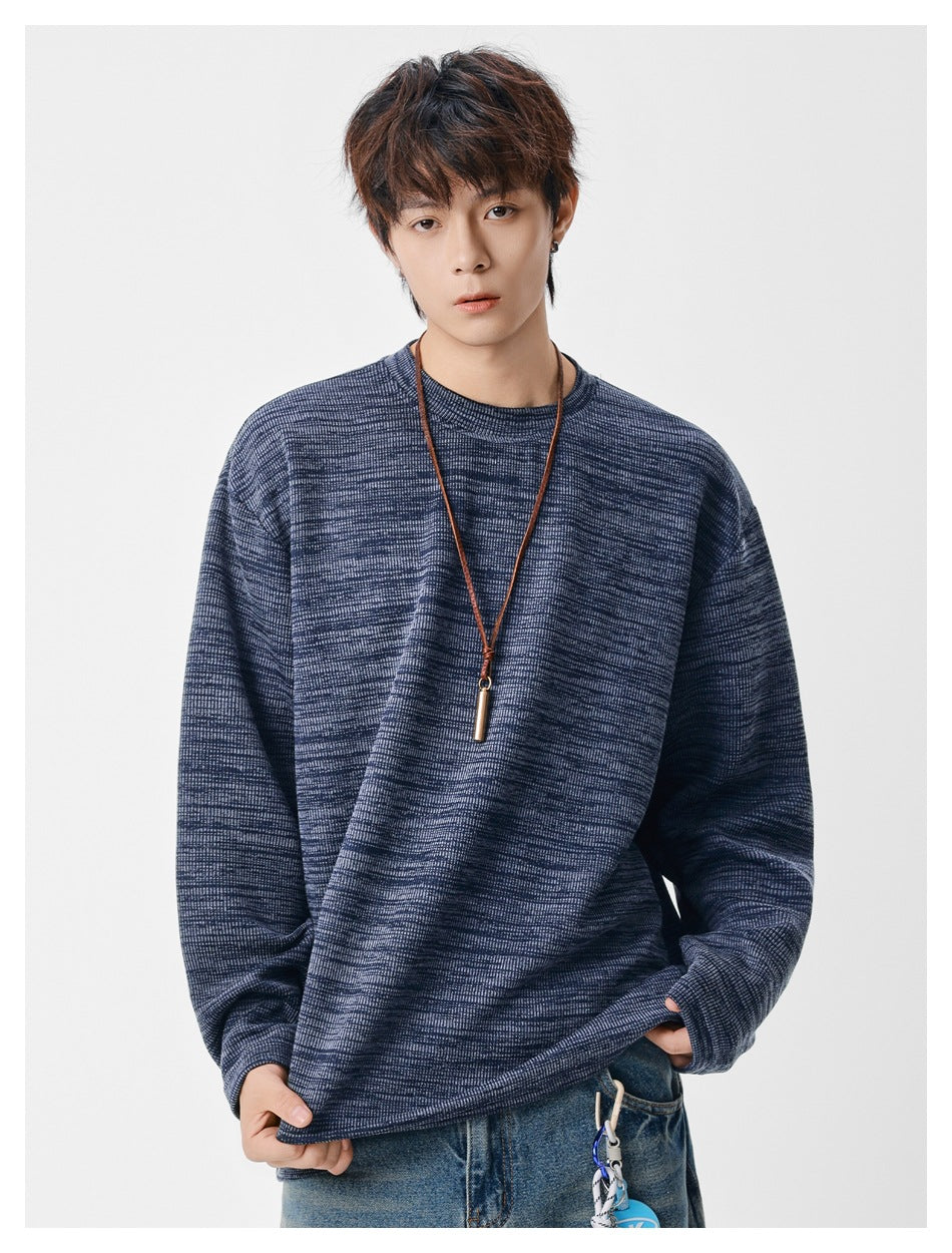 Model wearing a navy marled crewneck sweatshirt with long sleeves and a relaxed fit.