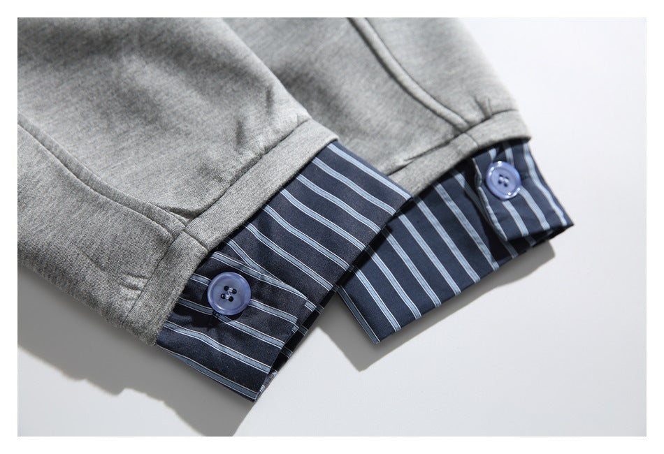 Close-up of a light gray sleeve cuff folded back to reveal a navy and pale blue striped lining with buttons.
